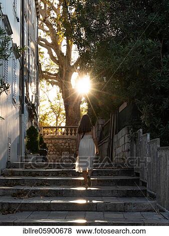 Stock Photo - Woman walking through an alley in New Dubrovnik, Croatia, Europe. Fotosearch