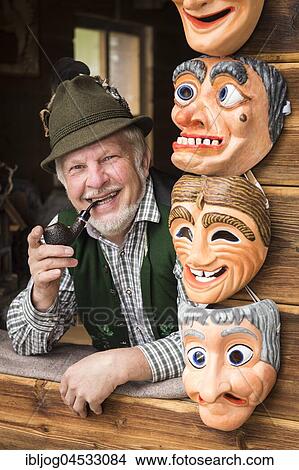 Wooden mask carver in a window, framed by painted wooden masks, wooden mask carving workshop, Bad Aussee, Styria, Austria, Europe View Large Photo Image Picture - Wooden mask carver in a window, framed by painted wooden masks, wooden mask carving workshop, Bad Aussee, Styria, Austria, Europe. Fotosearch