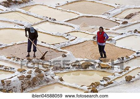 Stock Photo - Workers in the salt mines of Maras, Sacred Valley of the Incas, Province of Cusco, Peru, South America. Fotosearch
