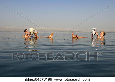 Young couple reads newspaper floating in Dead Sea, Jordan, Asia View Large Photo Image Stock Photo - Young couple reads newspaper floating in Dead Sea, Jordan, Asia. Fotosearch