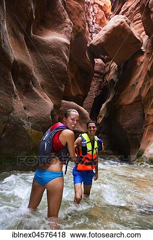 Stock Photo - Young couple under big rock at the canyon of Wadi Mujib, Jordan, Asia. Fotosearch