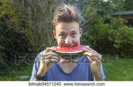 Young man eating a melon, Bavaria, Germany, Europe View Large Photo Image Stock Image - Young man eating a melon, Bavaria, Germany, Europe. Fotosearch