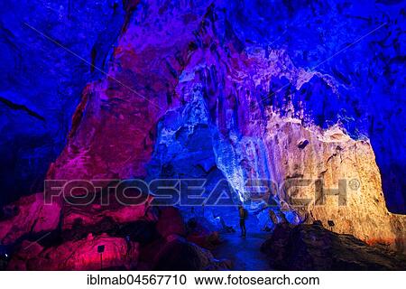 Young man looks at colorfully illuminated stalactite cave, Nebelhöhle, Sonnenbühl, Swabian Alb, Baden-Württemberg, Germany, Europe View Large Photo Image Stock Image - Young man looks at colorfully illuminated stalactite cave, Nebelhöhle, Sonnenbühl, Swabian Alb, Baden-Württemberg, Germany, Europe. Fotosearch