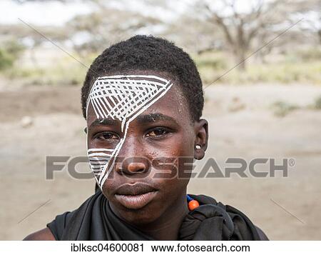 Stock Image - Young Massai warrior with face painting, Tanzania, Africa. Fotosearch