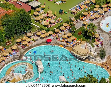 Stock Photo - Aerial view of Piani di Clodia Camping, campsite, swimming pool and sun terrace with parasols, campers, Lake Garda, Lazise, ​​Veneto, Italy, Europe. Fotosearch