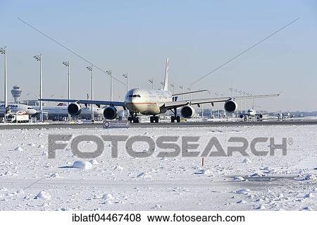 Stock Photo - Aircraft on snowy runway, Etihad Airlines, Airbus A 340, Munich Airport, Upper Bavaria, Bavaria, Germany, Europe. Fotosearch