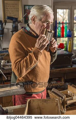 Barrel organ builder, workshop, man blowing into sound post, checking tones with his mouth, Grassau, Upper Bavaria, Bavaria, Germany, Europe View Large Photo Image Stock Photography - Barrel organ builder, workshop, man blowing into sound post, checking tones with his mouth, Grassau, Upper Bavaria, Bavaria, Germany, Europe. Fotosearch