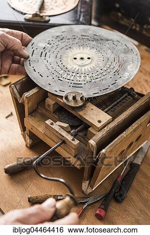 Stock Photograph - Barrel organ manufacture, perforated metal disk is placed on pin circle to check sounds, Grassau, Upper Bavaria, Bavaria, Germany, Europe. Fotosearch