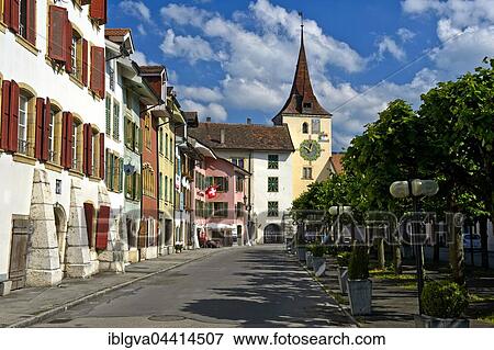 Stock Photo - Brightly colored houses, village square, north tower with clock, Le Landeron historic center, Neuchâtel Canton, Switzerland, Europe. Fotosearch
