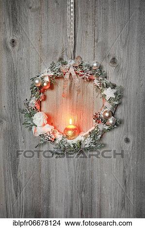 Picture - Christmas wreath on wooden wall with candle. Fotosearch