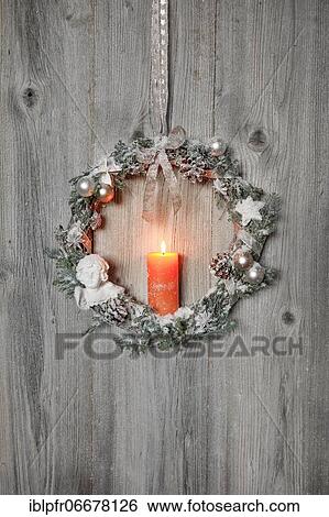 Christmas wreath on wooden wall with candle View Large Photo Image Stock Photograph - Christmas wreath on wooden wall with candle. Fotosearch