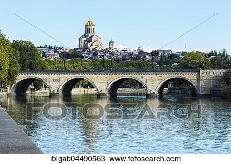 Chughureti or Saarbrucken bridge over Mtkvari river, Holy Trinity Cathedral on the hill, Tbilisi, Georgia, Asia View Large Photo Image Stock Image - Chughureti or Saarbrucken bridge over Mtkvari river, Holy Trinity Cathedral on the hill, Tbilisi, Georgia, Asia. Fotosearch