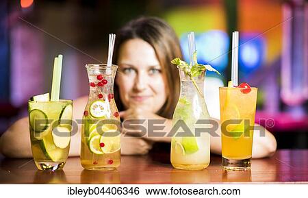 Stock Photograph - Cocktails with woman leaned against table, Stuttgart, Baden-Württemberg, Germany, Europe. Fotosearch