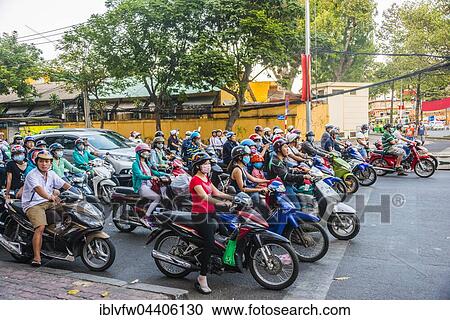 Stock Image - Crowd of scooter riders waiting at traffic light, Ho Chi Minh City, Vietnam, Asia. Fotosearch