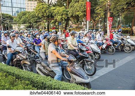 Stock Image - Crowd of scooter riders waiting at traffic light, Ho Chi Minh City, Vietnam, Asia. Fotosearch