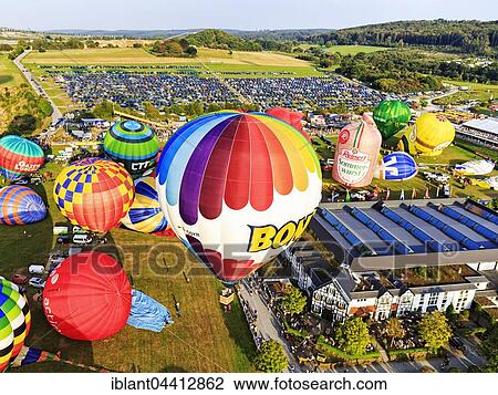 Stock Image - Different colored hot air balloons rising into the air, hot air balloon festival, 26th international Warsteiner Montgolfiade, Warstein, Sauerland, North Rhine-Westphalia, Germany, Europe. Fotosearch