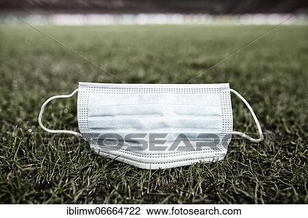 Stock Image - Discarded face mask lies on the ground on grass, Mercedes-Benz Arena, Stuttgart, Baden-Württemberg, Germany, Europe. Fotosearch