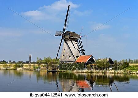 Dutch windmill over a canal, UNESCO World Heritage Site Kinderdijk, Alblasserwaard polder, South Holland, The Netherlands, Europe View Large Photo Image Stock Image - Dutch windmill over a canal, UNESCO World Heritage Site Kinderdijk, Alblasserwaard polder, South Holland, The Netherlands, Europe. Fotosearch