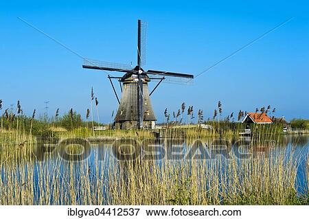 Dutch windmill over a canal, UNESCO World Heritage Site Kinderdijk, Alblasserwaard polder, South Holland, The Netherlands, Europe View Large Photo Image Stock Photo - Dutch windmill over a canal, UNESCO World Heritage Site Kinderdijk, Alblasserwaard polder, South Holland, The Netherlands, Europe. Fotosearch