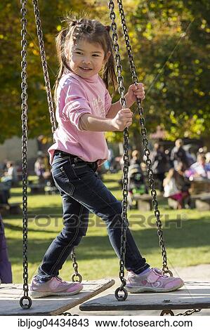 Eurasian girl standing on swing, Poing, Bavaria, Germany, Europe View Large Photo Image Stock Image - Eurasian girl standing on swing, Poing, Bavaria, Germany, Europe. Fotosearch