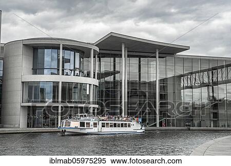 Stock Photography - Excursion boat on the Spree, Paul-Löbe-Haus near cloudy sky, government district, Mitte, Berlin, Germany, Europe. Fotosearch