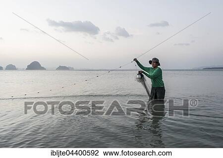 Fisherman is in the water and fishing with a net, Tubkaek Beach, Krabi Province, Thailand, Asia View Large Photo Image Stock Image - Fisherman is in the water and fishing with a net, Tubkaek Beach, Krabi Province, Thailand, Asia. Fotosearch