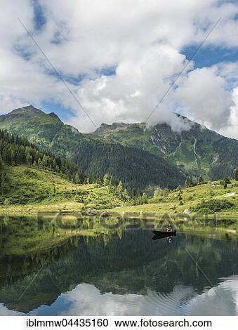 Fisherman on Lake Riesachsee with reflection of forest and mountains, Rohrmoos-Untertal, Schladming Tauern, Schladming, Styria, Austria, Europe View Large Photo Image Stock Image - Fisherman on Lake Riesachsee with reflection of forest and mountains, Rohrmoos-Untertal, Schladming Tauern, Schladming, Styria, Austria, Europe. Fotosearch