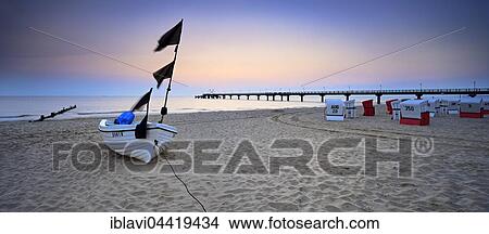 Picture - Fishing boat, pier and chairs on beach at sunrise, Baltic resort Bansin, Usedom, Mecklenburg-Western Pomerania, Germany, Europe. Fotosearch