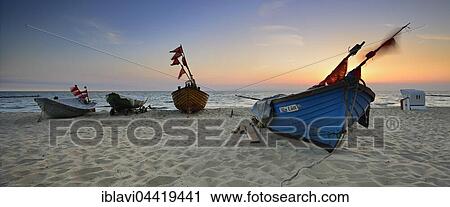Stock Image - Fishing boats on beach at sunrise, Kölpinsee, Usedom, Mecklenburg-Western Pomerania, Germany, Europe. Fotosearch