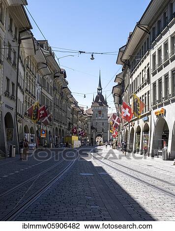 Stock Image - Flags on a row of houses in the old town of Bern, clock tower Zytglogge in the back, Inner City, Bern, Canton Bern, Switzerland, Europe. Fotosearch