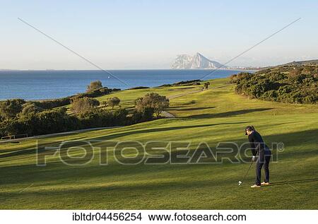 Golfer at La Alcaidesa Golf Resort with Mediterranean Sea and Rock of Gibraltar, Cádiz, Andalusia, Spain, Europe View Large Photo Image Picture - Golfer at La Alcaidesa Golf Resort with Mediterranean Sea and Rock of Gibraltar, Cádiz, Andalusia, Spain, Europe. Fotosearch