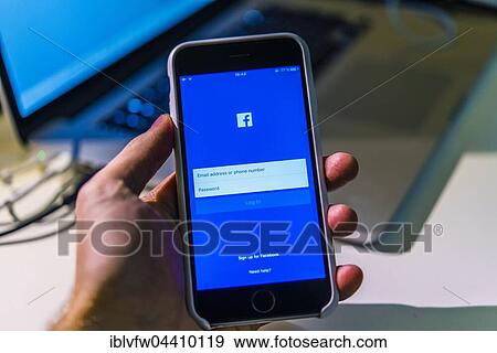 Hand holding iPhone 6S with open Facebook app on screen View Large Photo Image Stock Photo - Hand holding iPhone 6S with open Facebook app on screen. Fotosearch