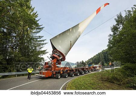 Stock Photograph - Heavy transport, wind turbine blade on heavy goods vehicle, curvy road in Schönau, Black Forest, Baden-Württemberg, Germany, Europe. Fotosearch