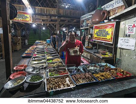 Stock Image - Indonesian food at booth, cheerful seller, thumbs up, Food Market, Yogyakarta, Java, Indonesia, Asia. Fotosearch