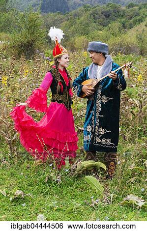 Stock Photograph - Kazakh man singing and playing the dombra for a woman, Kazakh ethnographic village aul Gunny, Talgar, Almaty, Kazakhstan, Asia. Fotosearch