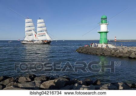 Lighthouse with sailing boat Mercedes at back, Hanse Sail, harbour entrance, port entrance Warnemünde, Mecklenburg-Western Pomerania, Germany, Europe View Large Photo Image Picture - Lighthouse with sailing boat Mercedes at back, Hanse Sail, harbour entrance, port entrance Warnemünde, Mecklenburg-Western Pomerania, Germany, Europe. Fotosearch