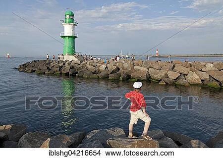 Little boy stands at pier, lighthouse, port entrance Warnemünde, Mecklenburg-Western Pomerania, Germany, Europe View Large Photo Image Picture - Little boy stands at pier, lighthouse, port entrance Warnemünde, Mecklenburg-Western Pomerania, Germany, Europe. Fotosearch