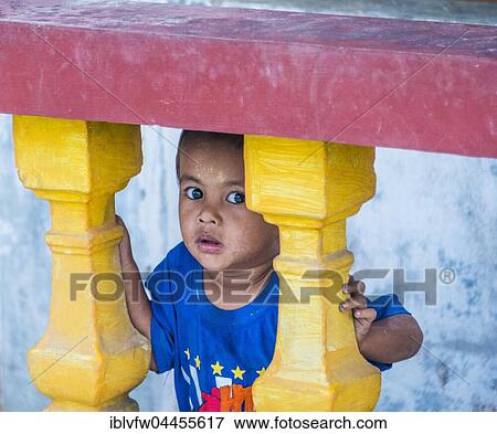 Little native boy looking through colourful balustrade, scared, Yangon, Myanmar, Asia View Large Photo Image Stock Photo - Little native boy looking through colourful balustrade, scared, Yangon, Myanmar, Asia. Fotosearch