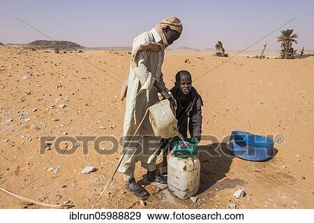 Local boys pulling out water out of a well in the desert, Sahara between Ounianga Kebir and Faya, Chad, Africa View Large Photo Image Stock Photo - Local boys pulling out water out of a well in the desert, Sahara between Ounianga Kebir and Faya, Chad, Africa. Fotosearch