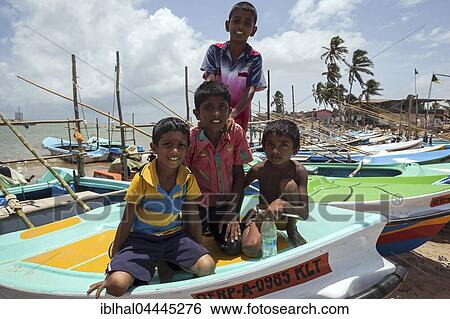 Local children sitting on fishing boat in harbour, Beruwela, Western Province, Sri Lanka, Asia View Large Photo Image Stock Photograph - Local children sitting on fishing boat in harbour, Beruwela, Western Province, Sri Lanka, Asia. Fotosearch