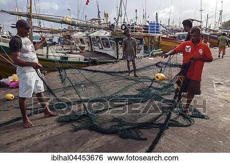 Stock Photograph - Local men untangling fishing nets in harbour, Beruwela, Western Province, Sri Lanka, Asia. Fotosearch