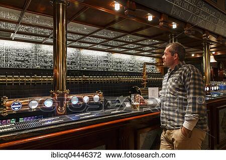 Man holding a glass of beer at Ølhallen, oldest pub in Tromso, Troms, Norway, Europe View Large Photo Image Stock Image - Man holding a glass of beer at Ølhallen, oldest pub in Tromso, Troms, Norway, Europe. Fotosearch