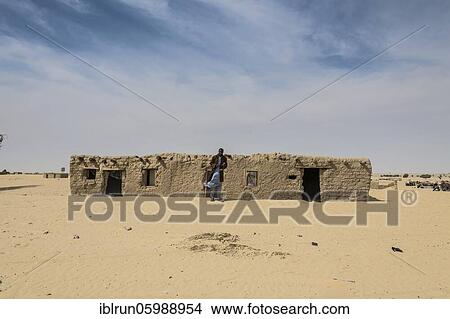Man in front of traditional mud house, a village in the desert, between Faya-Largeaux and N'Djamena, Sahara, Chad, Africa View Large Photo Image Picture - Man in front of traditional mud house, a village in the desert, between Faya-Largeaux and N'Djamena, Sahara, Chad, Africa. Fotosearch