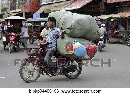 Stock Photograph - Man with moped and large sacks, Phnom Penh, Cambodia, Asia. Fotosearch