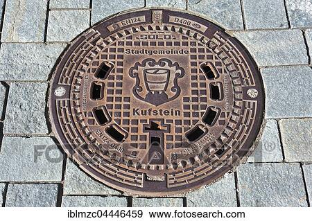 Stock Photo - Manhole with coat of arms of the Municipality Kufstein, Tyrol, Austria, Europe. Fotosearch