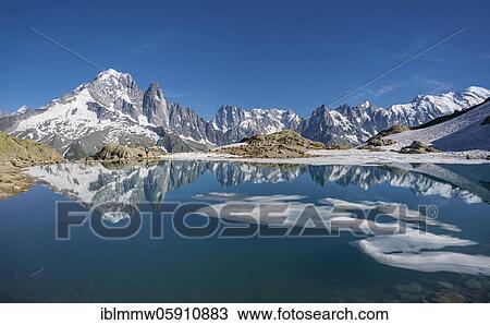 Stock Image - Mountain panorama, ice floe on Lac Blanc, mountain peaks reflected in mountain lake, Grandes Jorasses and Mont Blanc massif, Chamonix-Mont-Blanc, Haute-Savoie, France, Europe. Fotosearch