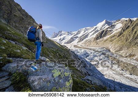 Stock Image - Mountaineer standing in front of glacier, high alpine mountain landscape, Lower Ice Sea, Finsteraarhorn, Agasszishorn, Großes Fiescherhorn, Bernese Oberland, Switzerland, Europe. Fotosearch