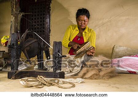 Native woman spinning sheep's wool with traditional spinning wheel in front of house, Ghandruk, Kaski District, Nepal, Asia View Large Photo Image Picture - Native woman spinning sheep's wool with traditional spinning wheel in front of house, Ghandruk, Kaski District, Nepal, Asia. Fotosearch