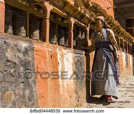 Native woman walking along Mani Wall and spinning prayer wheels, Kagbeni, Mustang District, Nepal, Asia View Large Photo Image Stock Photography - Native woman walking along Mani Wall and spinning prayer wheels, Kagbeni, Mustang District, Nepal, Asia. Fotosearch