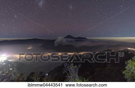 Stock Image - Night sky, stars, smoking volcano, Gunung Bromo, Mount Batok, Mount Kursi, Mount Semeru, Bromo Tengger Semeru National Park, Java, Indonesia, Asia. Fotosearch